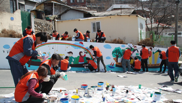 시골마을을 찾아 낡은 담장에 벽화그리기 봉사활동을 하고 있다.